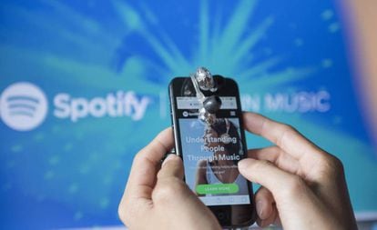 Un usuario con un móvil usa la 'app' de Spotify.