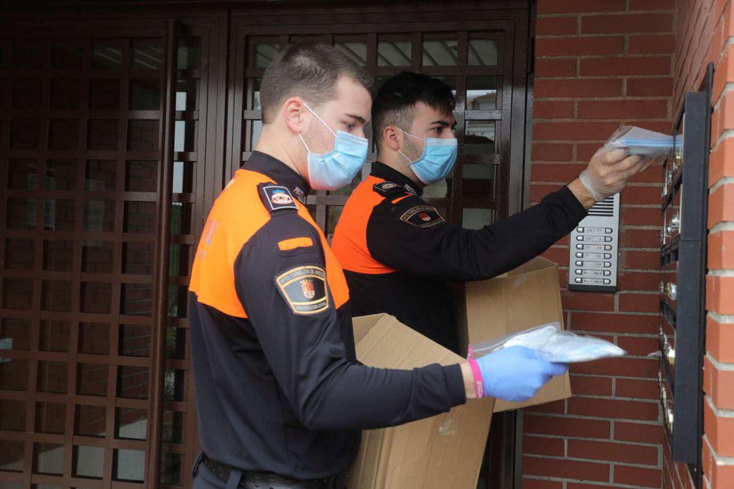 Dos voluntarios de Protección Civil, durante el reparto de mascarillas este jueves en Torrejón de Ardoz.