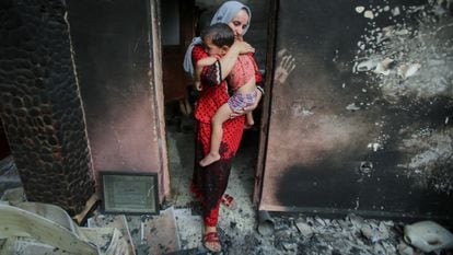 Souhila Belkati e suo figlio in ciò che resta della loro casa dopo un incendio a Bejaia (Algeria).
