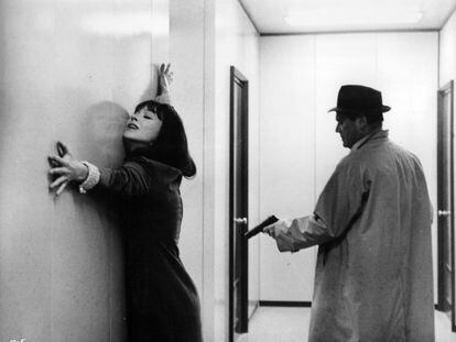 Eddie Constantine apunta con una pista a Anna Karina en la película 'Alphaville' (1965), de Jean-Luc Godard.