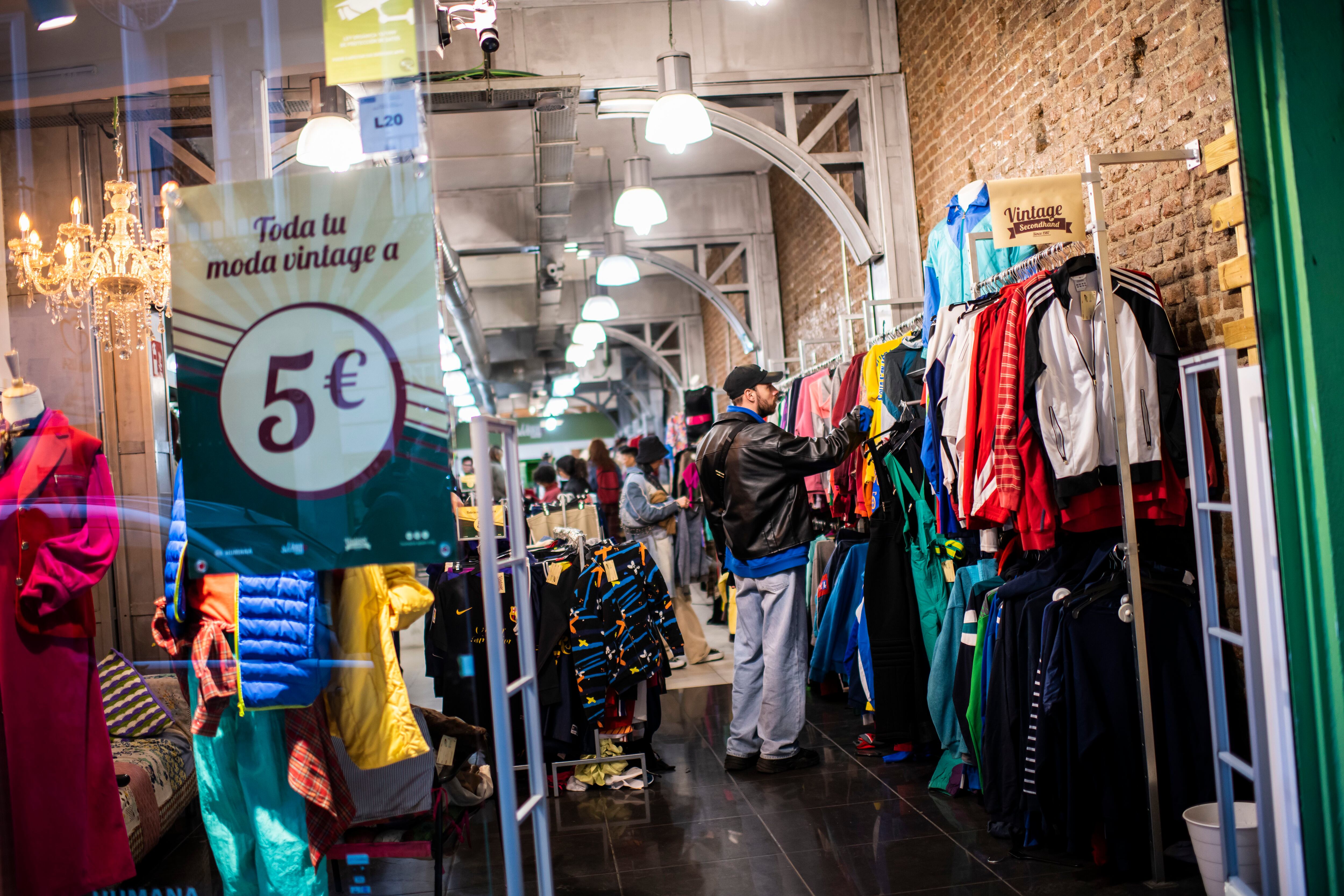 Reportaje sobre compra de segunda mano.Personas viendo ropa y comprando en la tienda Humana Vintage de la calle hortaleza.