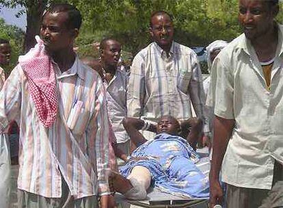 Varios somalíes transportan a un familiar herido hasta el hospital de Madina ayer en Mogadiscio.