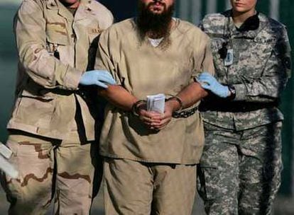 Dos militares estadounidenses conducen a un detenido en la prisión de Guantánamo.