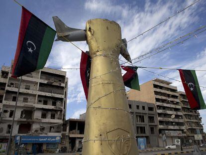 Símbolos gadafistas con edificios destrozados al fondo, en la avenida de Trípoli en Misrata.
