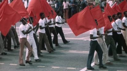 Desfile de civiles en África con banderas comunistas.