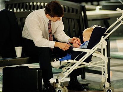 Un hombre con un bebé en su silla de paseo.