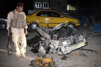 Un soldado iraquí, junto a los restos del coche bomba que explotó en el barrio chií de Ciudad Sáder.