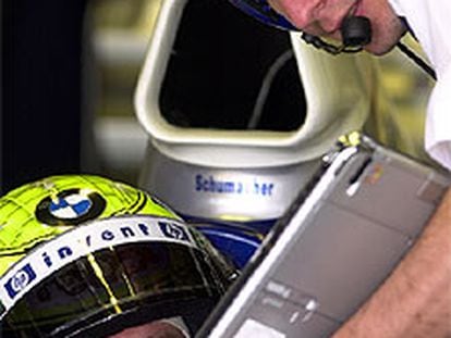 Ralf Schumacher contrasta con un mecánico datos telemétricos.