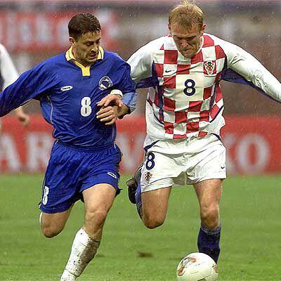 Prosinecki (derecha) pugna por el balón con el bosnio Sabic en 2002.