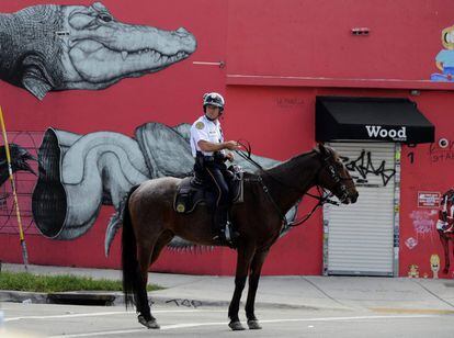 Un policía montado pasa junto a un mural en el distrito de Wynwood.