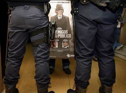 Un trabajador del hospital Clínico recibe a Aguirre con una pancarta crítica.