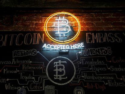 Un neón con el símbolo del bitcoin brilla en la pared de un bar en Ciudad de México.