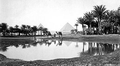 Beduinos, en un oasis con las pirámides de Gizeh al fondo, en una foto de 1869.