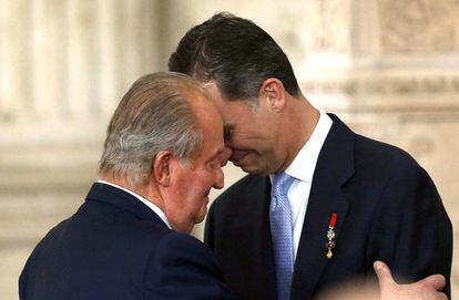 El rey Juan Carlos abraza al príncipe de Asturias, Felipe de Borbón, tras firmar la ley orgánica de la  abdicación.