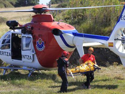 Miembros del equipo de rescate trasladan este domingo a la mujer fallecida al caer por un acantilado en Muskiz. 