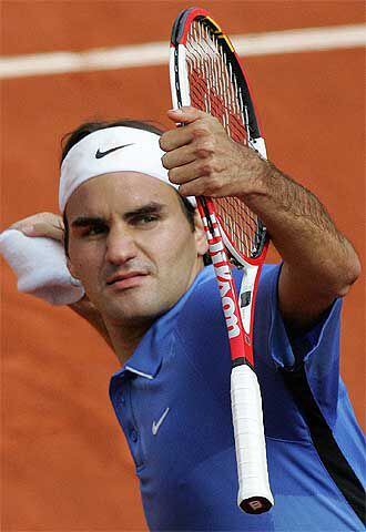 Roger Federer lanza, de recuerdo, la muñequera al público.