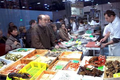 Varias personas compran en un mercado de Bilbao. 
