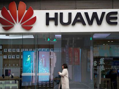 Una mujer pasa caminando por delante de un logo de Huawei el pasado diciembre en un centro comercial de Shangái (China).