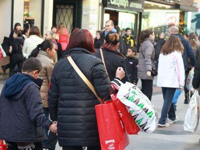 Un grupo de personas pasean con sus compras por la popular calle comercial madrile&ntilde;a de Preciados. 