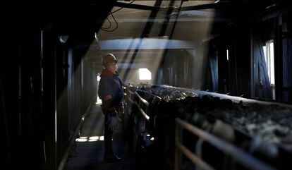 Un trabajador vigila una cadena en una planta de carbón en la provincia de Shanxi, China.