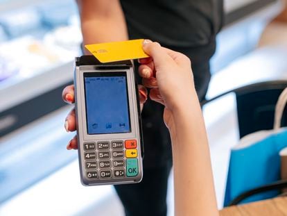 Una mujer realiza una compra con su tarjeta de crédito.