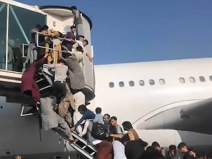 Afganos intentan acceder a un avión en el aeropuerto de Kabul, este lunes.