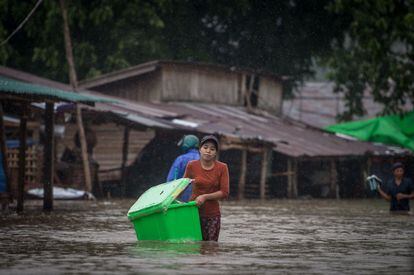Una mujer carga sus pertenencias en el municipio inundado del distrito de Mawlamyine en el estado de Mon, Myanmar.