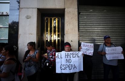 Personas llevan carteles en protesta contra el hambre, afuera del ministerio de Capital Humano, este lunes en Buenos Aires.
