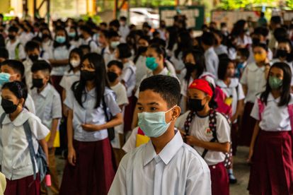 Los estudiantes filipinos esperan en fila para ingresar a sus aulas en el patio de una escuela después de que comience la educación presencial en las escuelas públicas de Manila, Filipinas, el 22 de agosto de 2022.