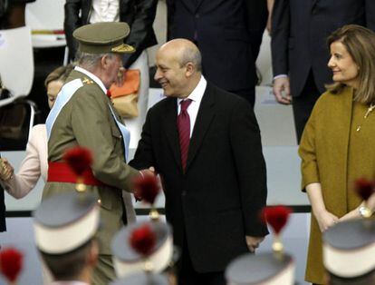 El rey Juan Carlos saluda al ministro de Educación, José Ignacio Wert, en presencia de la ministra de Empleo, Fátima Báñez, a su llegada a la plaza de Neptuno de Madrid para presidir el desfile militar organizado hoy con motivo de la celebración de la Fiesta Nacional.