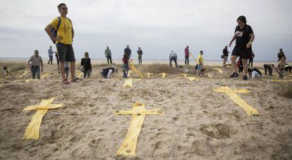 Cruces amarillas hechas con toallas en la playa de Mataró.
