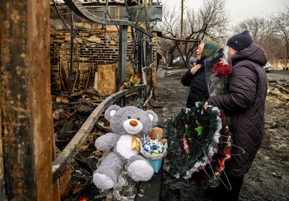 Dos personas lloran a la familia con tres niños muertas en un incendio causado por drones rusos en Jarcov (Ucrania), este 9 de febrero. 