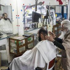 El peluquero don Manuel con un cliente.