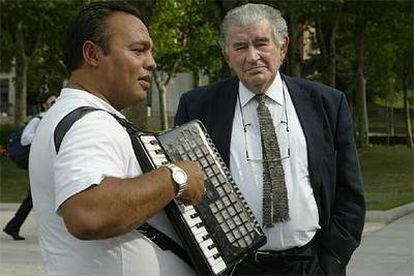 Antonio Gamoneda, ayer en Madrid, junto a un músico callejero.