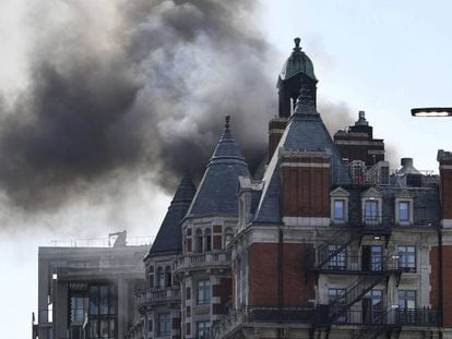 Una columna de humo se eleva sobre el edificio afectado por un incendio en el barrio de Knightsbridge, en Londres, este miércoles.