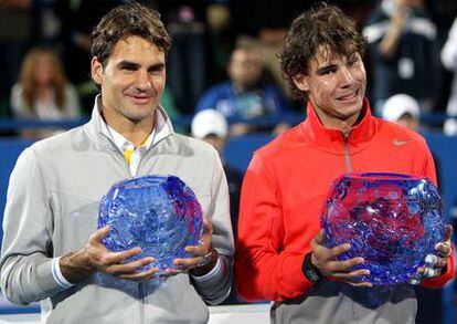 Roger Federer (izquierda) y Rafa Nadal muestran los trofeos para el finalista y el ganador del torneo de exhibición de Abu Dabi. El español ha ganado la final al suizo en dos sets (7-6, 7-6).