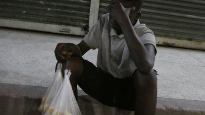 John (nombre ficticio), de 14 años, con una bolsa de la caña de azúcar que vende en las calles de Dar es Salam (Tanzania).