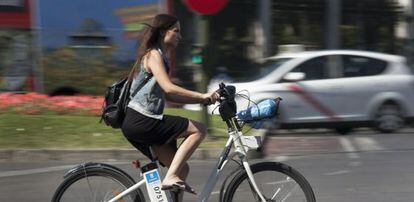 Un usuario utiliza una bici de alquiler 'Bici-mad' en el centro.