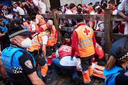 Los servicios de emergencias atienden a uno de los heridos en el tercer encierro de San Fermín.