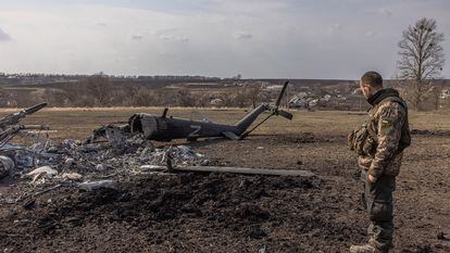 Un soldado ucranio contemplaba el jueves un helicóptero ruso destruido, con la letra 'Z', el símbolo escogido por las tropas invasoras, cerca de Járkov, en el noreste del país.