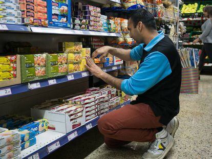 Un franquiciado coloca los productos en las estanter&iacute;as de un supermercado de Sants.