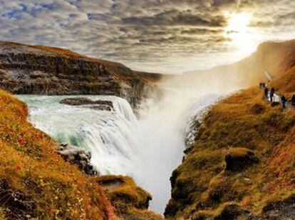 Turistas paseando frente a la cascada de Gullfoss (islandia) en otoño.