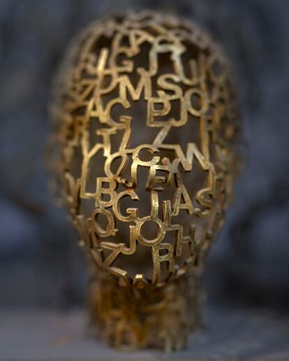 Cabeza esculpida con letras.