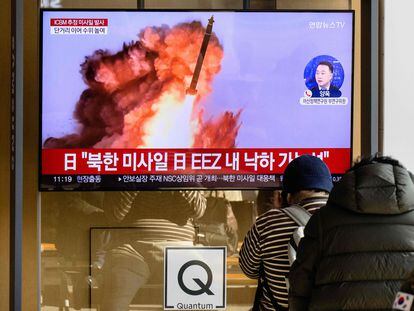 Varias personas observan una pantalla que emite imágenes del misil lanzado por Corea del Norte, este viernes en una estación de trenes en Seúl.