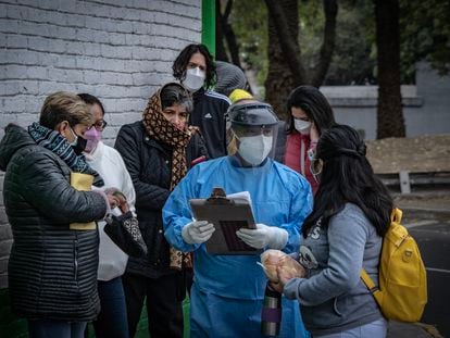 Personal sanitario informa sobre el registro para recibir vacunas contra la covid-19, en el centro de salud Dr. José Ma. Rodríguez, en Ciudad de México, el 23 de diciembre.