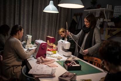 La profesora Begoña Plaza, de pie, da algunas directrices a los alumnos de la clase de costura de La Laborteca, un estudio en Madrid. 