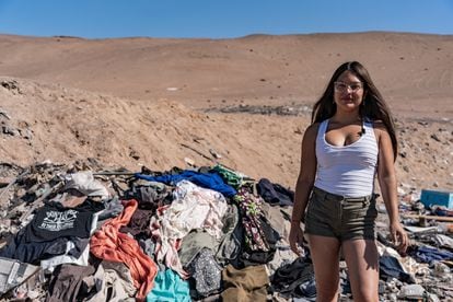 Ángela Astudilo entre montañas de ropa en el desierto de Atacama.
