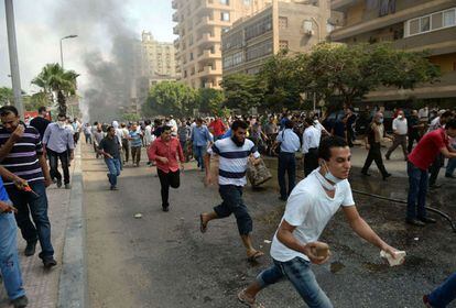 Seguidores de los Hermanos Musulmanes huyen de la policía en una calle de El Cairo.