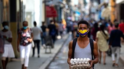 Cuba, la Habana hombre camina llevando un cartón de huevos