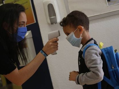 Una professora pren la temperatura a un nen a l'escola Mare de Déu de Monserrat de Terrassa.